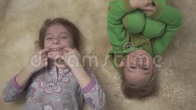 穿着睡衣的快乐小孩子躺在地板上，铺着蓬松的地毯。 <strong>兄妹</strong>俩在一起玩得很开心。 快乐